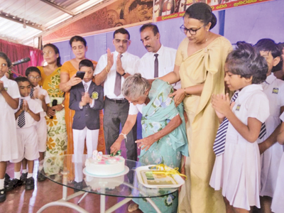 උපන් දින කේක් ගෙඩිය කපන ලිලී වයලට් මහත්මිය